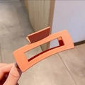 Vista detallada de la pinza de pelo grande mate coral para cabello grueso con diseño antideslizante - Estilo Mate Grande / Naranja