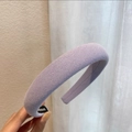 Nahaufnahme eines lavendelfarbenen gepolsterten Haarreifs mit Rippstrick und Handmade-Etikett - Creme-Violett