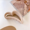 Pinza per capelli a cuore beige opaco con design traforato su sfondo minimale - Rosa pelle