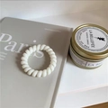 Weißer spiralförmiger Telefonkabel-Haargummi auf grauem Magazin für minimalistischen Look - Gelee-Weiß