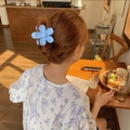 Gros plan d'une pince à cheveux fleur bleue mate utilisée pour un chignon français - Bleu ciel