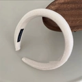 Primer plano de diadema acolchada crema con textura tejida y etiqueta artesanal - Blanco Roto