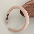 Detalle de la etiqueta artesanal en una diadema de esponja gruesa color crema - Color Té con Leche