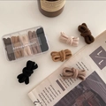 Detailed view of elastic hair ties in neutral earth tones stored in a clear five-grid box - Earth Tone