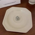 Close-up of a mini matte hair claw clip in sage green on a white ceramic plate - Gray