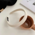 Dettaglio di un cerchietto spesso in tessuto crema con etichetta fatta a mano su una tazza - crema
