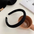 Dettaglio di un cerchietto in spugna nero con etichetta fatta a mano su fondo pulito - Nero