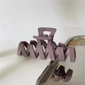 Macro shot of matte Morandi purple hair claw clip with unique wavy Z-shaped teeth design - Purple