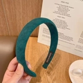 Detalle de una diadema de ante verde oscuro con etiqueta Hand Made sobre fondo retro - Verde Oscuro