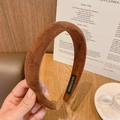 Detalle de una diadema de gamuza marrón que muestra la etiqueta hecha a mano sobre madera - Marrón