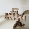 Matte beige large wavy hair claw clip in Korean retro style on a metallic tray - Pink