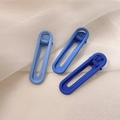 Close-up of three blue gradient oval hair clips on a soft white tulle background - Blue