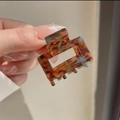 Close-up of square leopard checkered acetate hair claw with glossy tortoiseshell finish - Caramel Brown Tortoise Shell