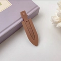 Sleek brown matte hair clip with duckbill design for women on lavender book - Coffee
