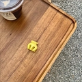 Close-up of a mini yellow hair claw clip on a wooden tray with outdoor lighting - Lemon Yellow