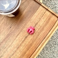 Gros plan extérieur d'une petite pince à cheveux rose brillante sur un plateau - rose vif