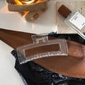 Macro view of 12.5cm large clear resin hair claw clip on a luxury wooden display - Large Square Jelly White Claw Clip approx 12.5cm