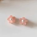 Close-up of pink flower hair clips with central pearl detail on a neutral surface - Pearlescent Pink