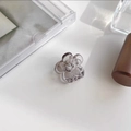 Close-up of a small translucent smoky grey flower hair claw with a visible metal spring - Jelly Grey