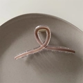 Detailed close-up of a mocha brown claw clip with a transparent finish on a grey ceramic plate - Milk Tea
