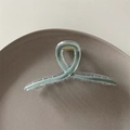 Detail view of sage green hair claw clip with transparent shell and golden spring - Teal