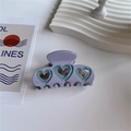 Close-up of lavender acetate hair claw clip featuring three hollow heart patterns - Purple