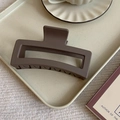Macro detail of the matte coffee-colored rectangular hair claw on a cream dotted tray - Matte Square Style / Large / Brown