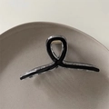 Detail of minimalist black and clear hair claw clip featuring elegant twist knot design - Black