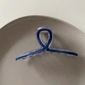 Close-up of minimalist dark blue translucent shark hair claw clip in a ceramic dish - Royal Blue