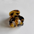 Close-up of tortoise shell pattern mini claw clip with smooth resin finish and spring - Brown Tortoiseshell