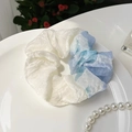 Λεπτομέρεια από μπλε και λευκό scrunchie σε κεραμικό πιάτο με κομψές πέρλες - Ουρανί Πολύχρωμο