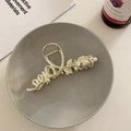 Dettaglio di un fermaglio per capelli a rosa dorata con perla su vassoio ceramico - Tulipano - Oro
