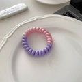 Detalle de coletero en espiral rosa y púrpura sobre un plato de cerámica blanca elegante - Rosa Púrpura