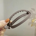 Dettaglio ravvicinato della clip a banana marrone scuro opaco con denti antiscivolo - Marrone