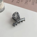 Detail of a mini leopard print hair claw clip with golden Barrette la france lettering - Black Polka Dot