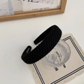 Détail d'un bandeau en tricot noir avec étiquette 'HANDMADE' et texture en grosse maille - Noir