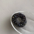 Dettaglio della texture a maglia colorata su questo elastico per capelli nero - Nero