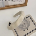Detail of a creamy white knitted thick headband showing handmade label and ribbed texture - Milky White