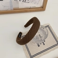 Gros plan du bandeau tricoté marron montrant la texture rayée et l'étiquette faite main - Café Foncé