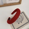 Detailed knit texture of red handmade headband leaning on a decorative glass - Burgundy