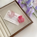 Detalle de dos mini pinzas para el cabello color caramelo en una bandeja de terciopelo - Rosa Roja