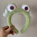 Vista detallada de la diadema de rana verde de felpa con ojos grandes bordados - Diadema de Rana