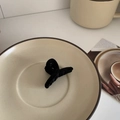Detail shot of black flocked hair claw clip on a minimalist ceramic plate with warm lighting - Bobby Pin / Black