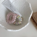 Detailopname van zachte pluche haarelastiekjes in roze en kleurrijke gebreide patronen - Candy Serie