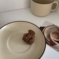Detail shot of a brown velvet hair claw clip on a ceramic plate for elegant styling - Pumpkin Clip / Brown