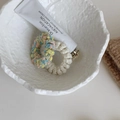 Gros plan détaillé d'élastiques à cheveux en tricot pelucheux dans un bol décoratif - Multicolore