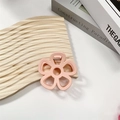 Detail der rosa hohlen Blumen-Haarklammer auf Wellenholzbrett mit mattem Finish - Hellrosa