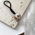 Détail de l'élastique à cheveux tulipe avec perle marbrée et texte Handmade doré - Jade Blanc