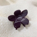 Primer plano de una pinza para el pelo con flor morada oscura y acabado de resina - Fucsia