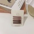 Set of four matte brown hair clips in gradient earth tones on a white display card - Ellipse